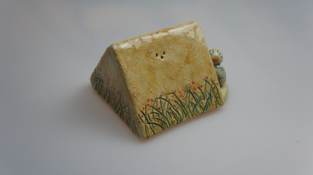 Peper en zoutstel 'Samen Kamperen' - Een keramisch kunstwerk met een tent en twee mensen ervoor.